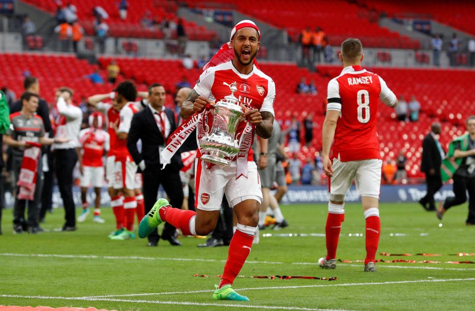 A jubilant Theo Walcott celebrates with the FA Cup trophy 