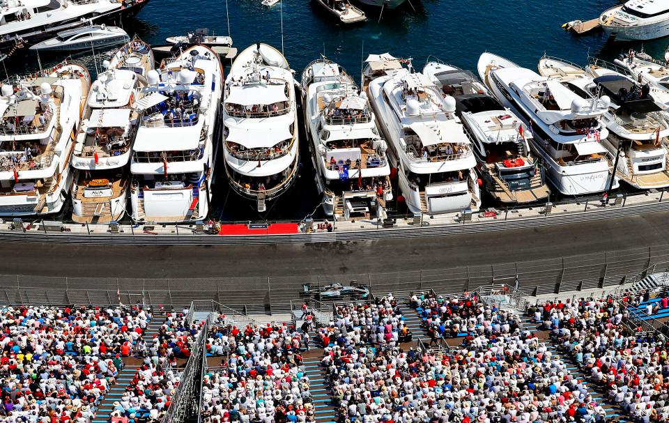 Lewis Hamilton drives past the yachts parked in Monte Carlo harbour which he would later party on