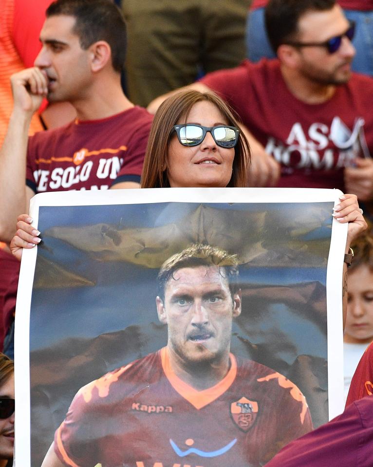 A Roma fan holds a big image of her idol Francesco Totti in his final game