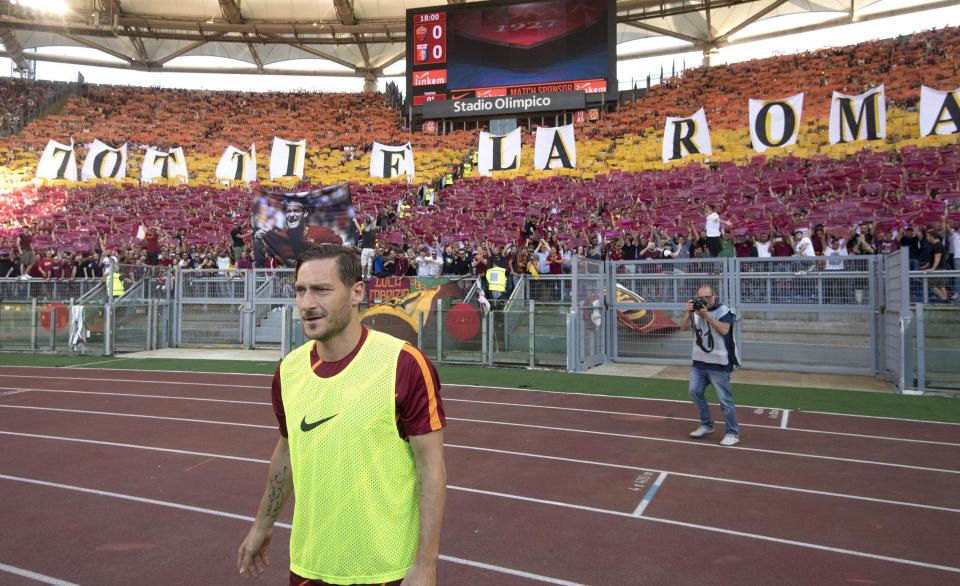 Francesco Totti stands against backdrop of Roma fans paying tribute