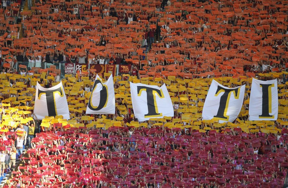 Roma fans hold up a banner in honour of the club's most famous icon