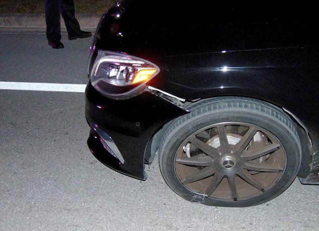  A damaged bumper hangs from the front of the car where a dazed Woods failed four sobriety tests