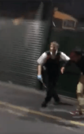 A police officer can be seen leading a person away from the scene