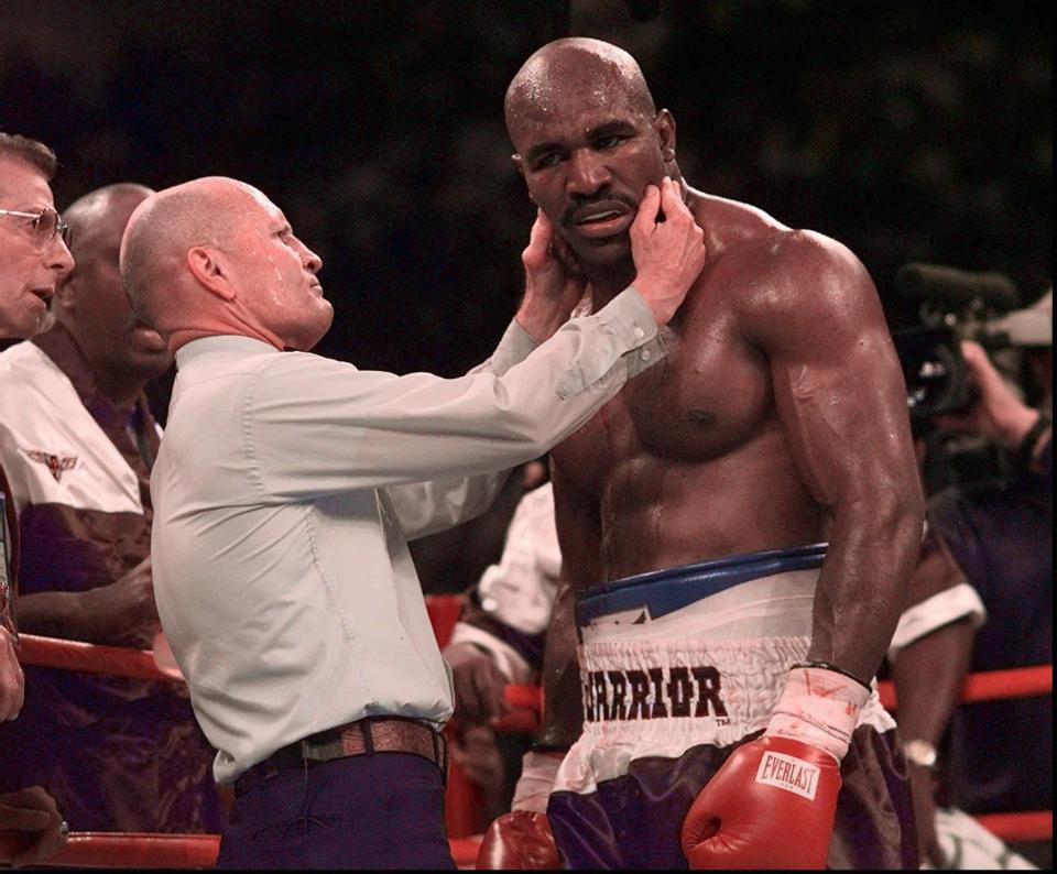  Evander Holyfield shows his savaged ear to referee Mills Lane in one of boxing's most shocking scenes