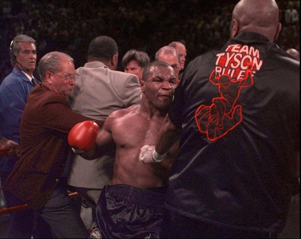  Dozens of police rushed into the ring to keep Tyson away from Holyfield