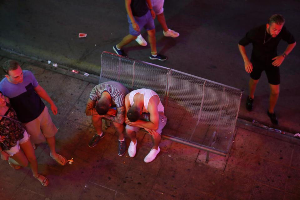  Two revellers rest on a public bench in Magaluf