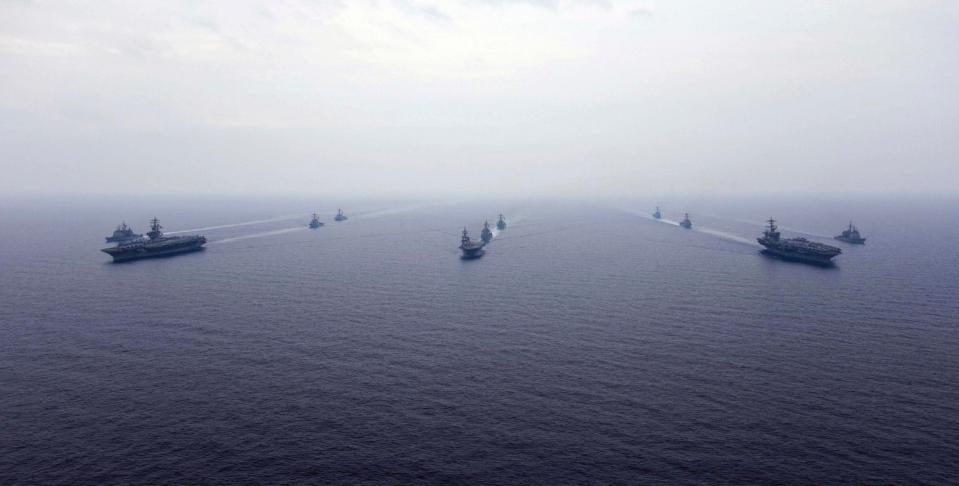  US Navy aircraft carriers, USS Ronald Reagan, left front, and USS Carl Vinson, right front, sail alongside one of Japan's four helicopter carriers the JS Hygua, centre front