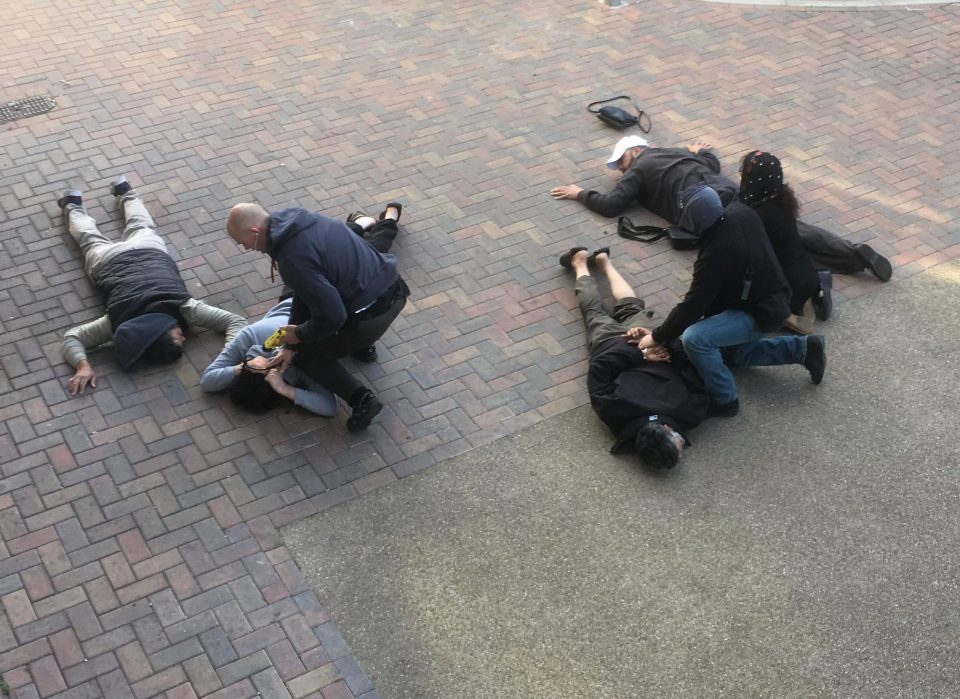  Officer with Taser pins two suspects to ground as colleague restrains two men and woman in a series of east London raids