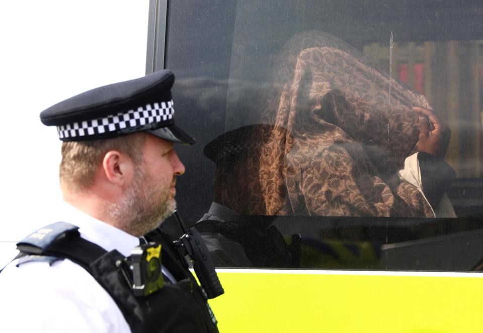  The detained individual sits inside a police vehicle after one of several raids conducted this morning