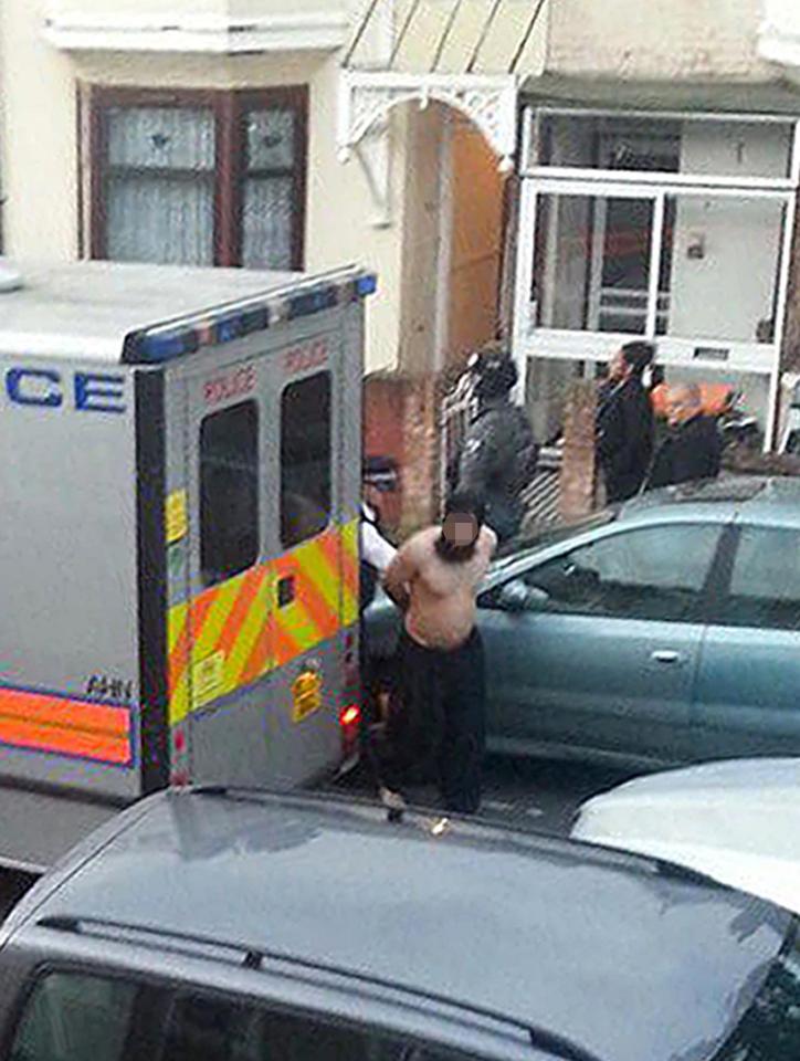  A man is led away by police in Caledon Road, east London, as police carried out raids