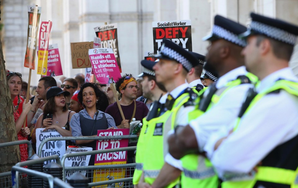 Police stand guard as protesters chant 