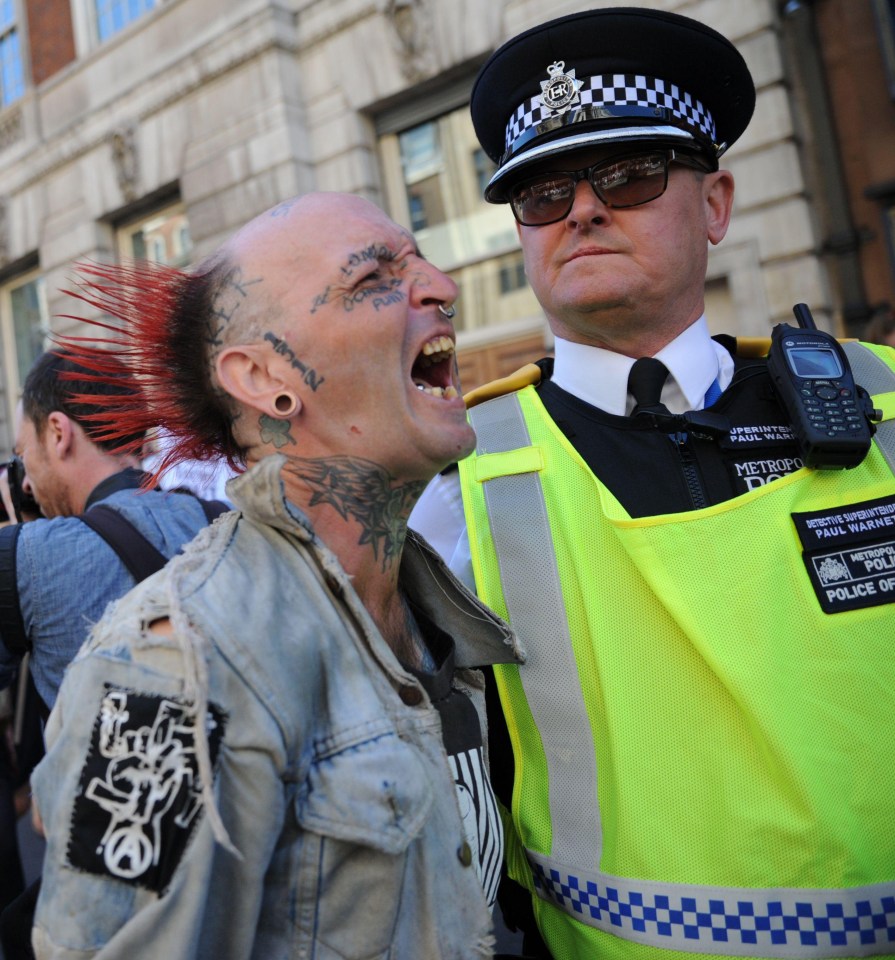 A man yells near the face of a Met Police officer during the protests