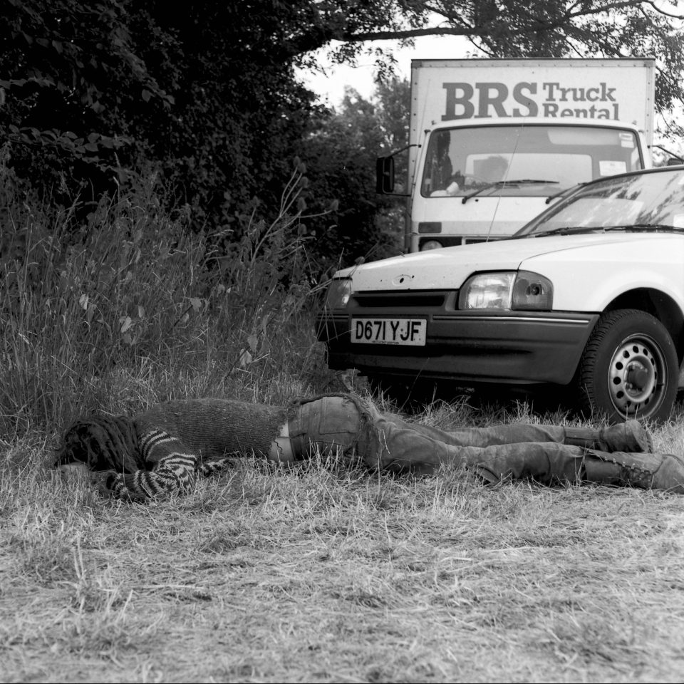  One shot from 1989 shows a passed-out traveller lying in the grass. Headlined by Elvis Costello, the festival resulted in £100,000 being raised for the Campaign for Nuclear Disarmament