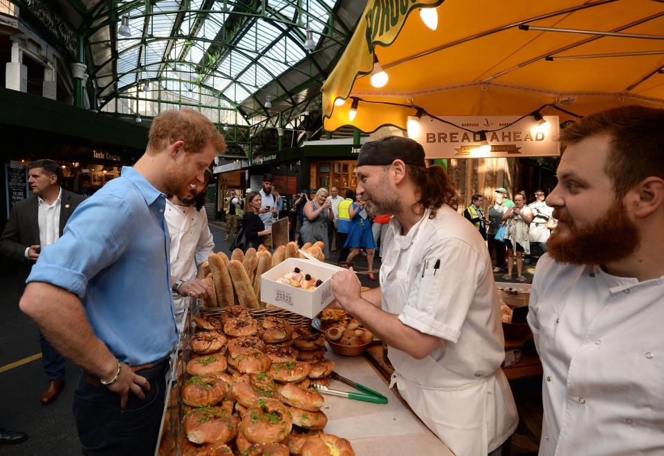  The royal eyes up a box of fresh baked goods in the historic market, which reopened yesterday