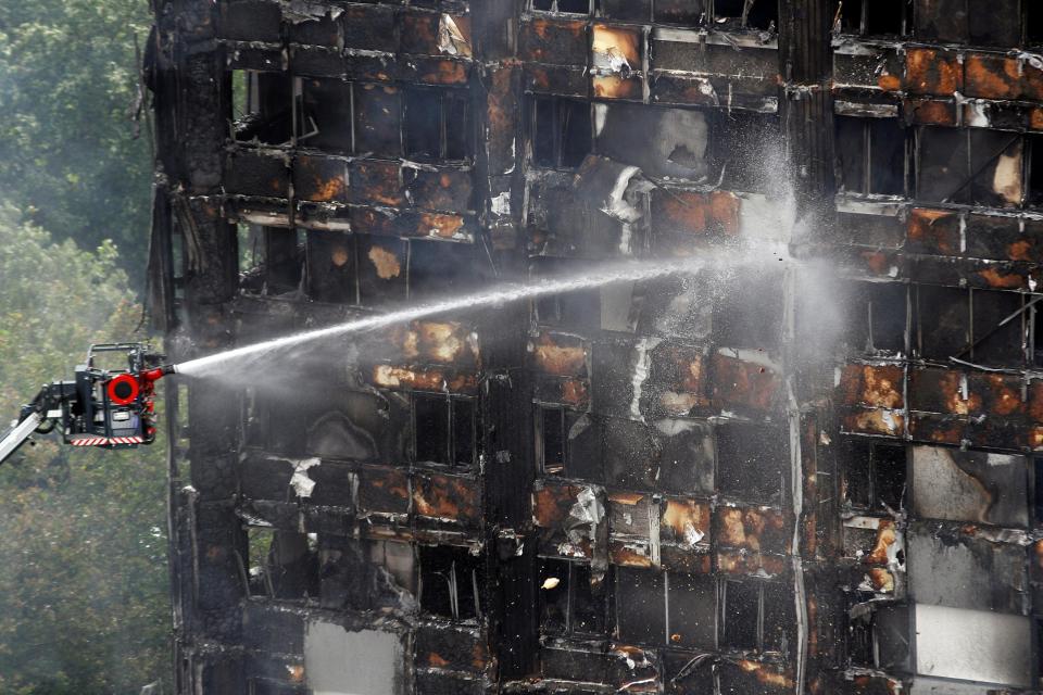  Firefighters still working on the gutted remains of the tower block