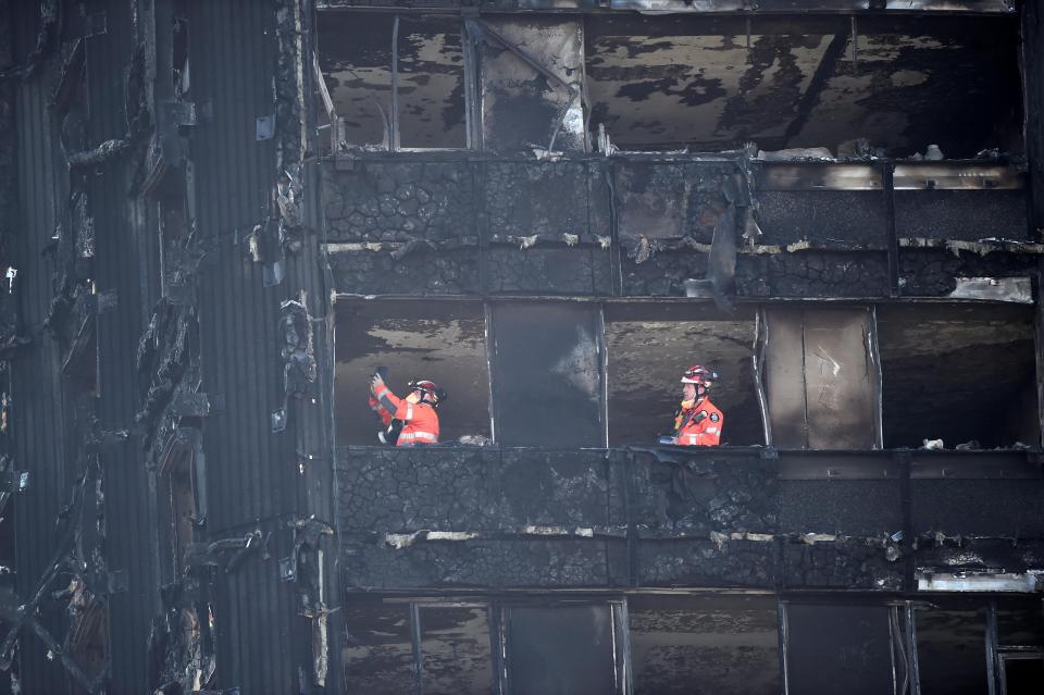  Members of the emergency services work inside the charred remains of the Grenfell apartment tower block in North Kensington