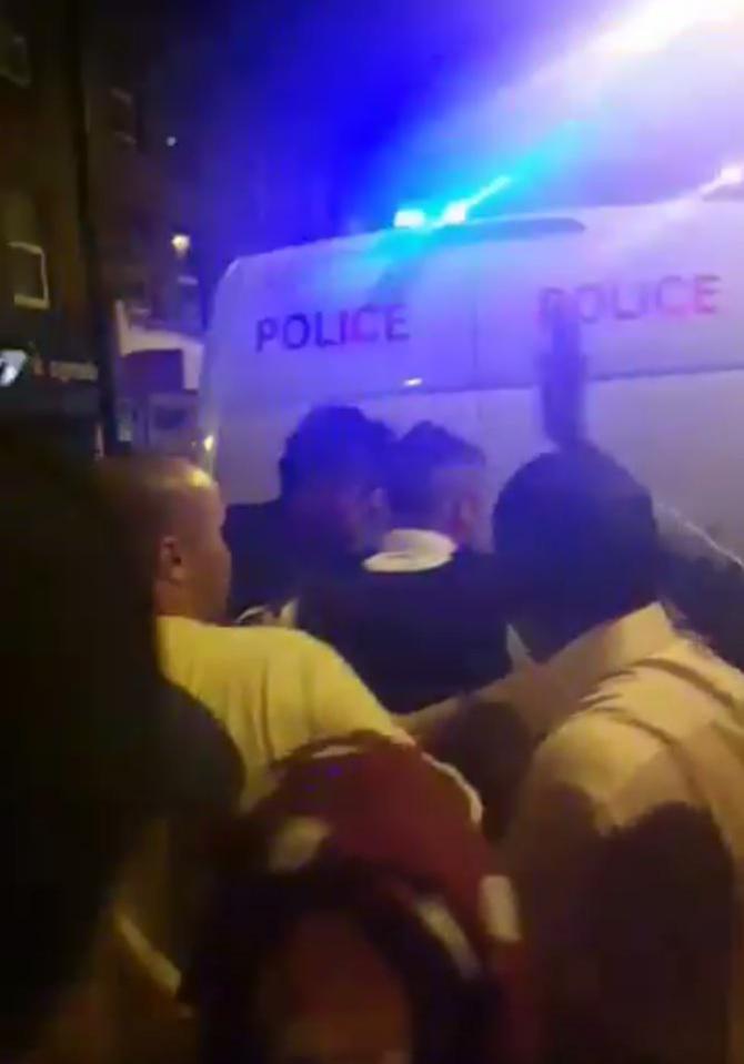  The man is led to the police van to heckles from the crowd watching him being taken away