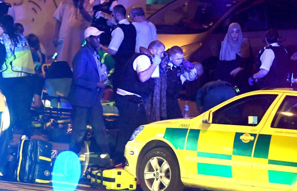  Police assist a woman caught up in the panic at Finsbury Park after a van was 'deliberately' driven at pedestrians