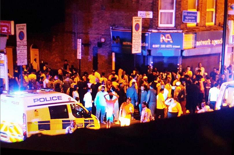  Dozens of people can be seen gathered on the junction close to Seven Sisters Road in the aftermath of the attack