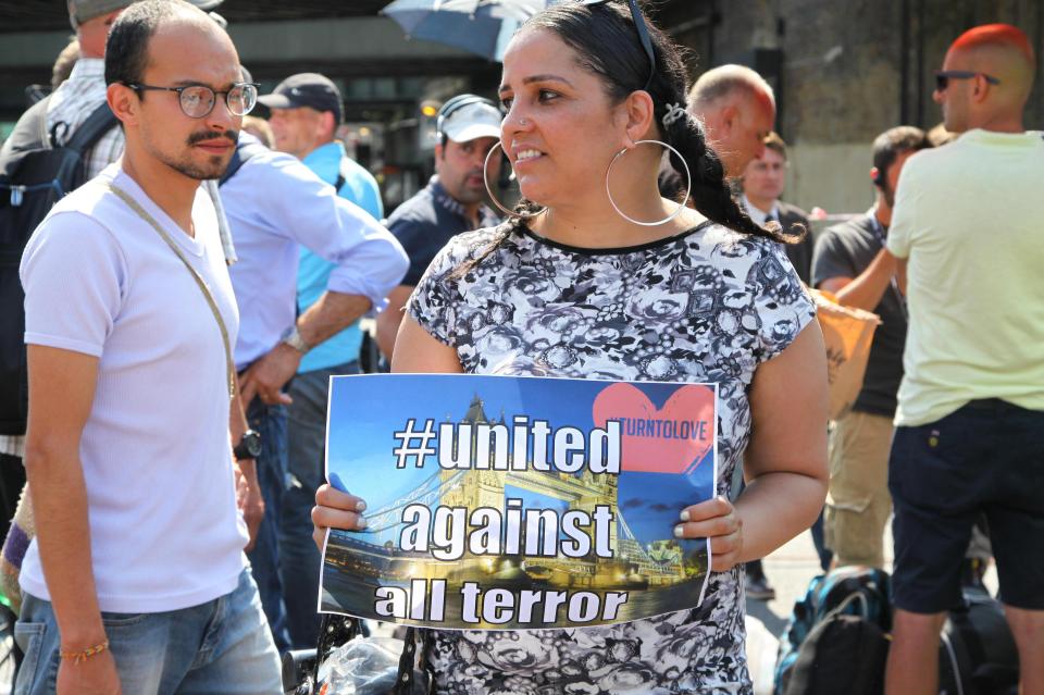  A woman holds a poster which reads 'United against all terror' after a van mowed down pedestrians in North London last night