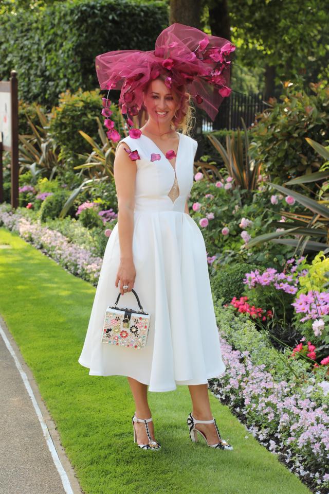  Making the most of the balmy June weather, one woman donned a white midi dress and jazzed it up with a large pink petal-adorned hat