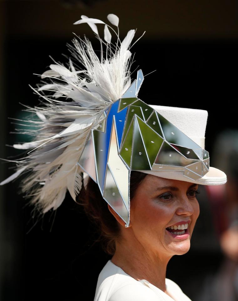  One woman was all smiles as she posed for photographers in her unusual headpiece that featured an abstract silver design and white feathers