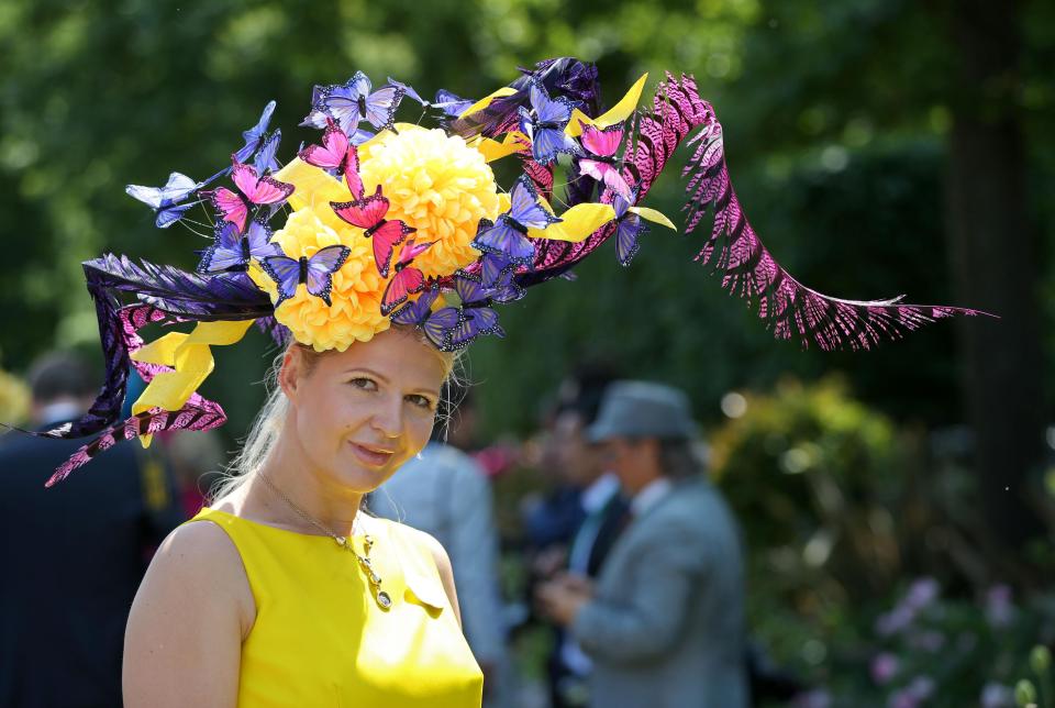  Making the most of the sunshine, one woman looked vibrant in a chic yellow dress and a large hat that was adorned with multi-coloured butterflies