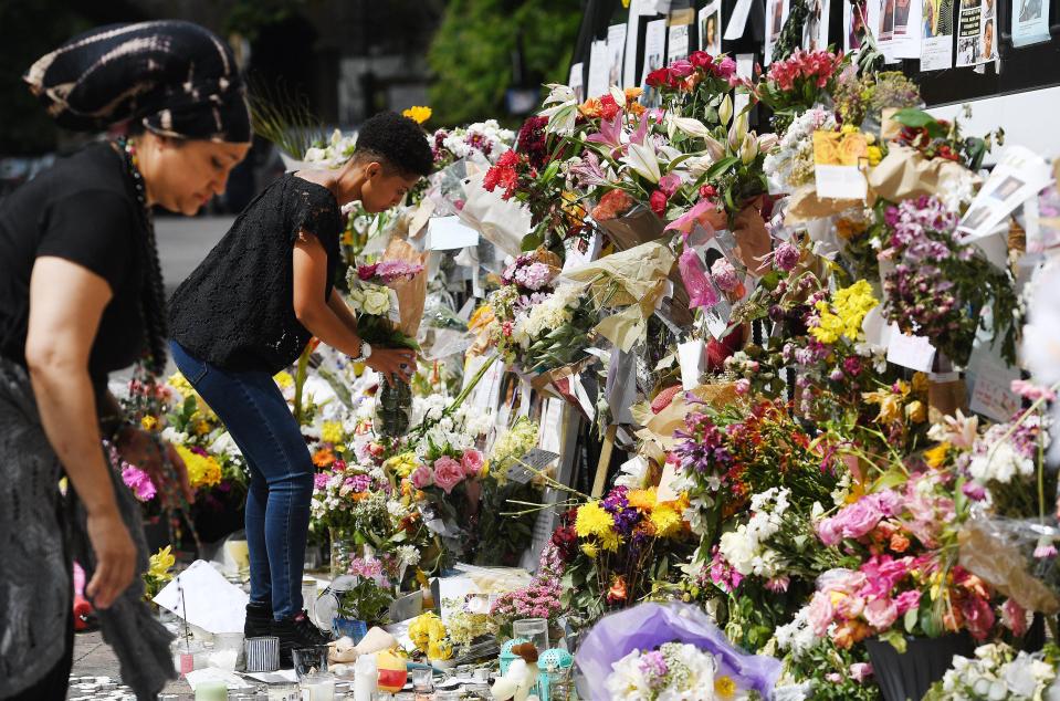  Tributes have been laid in the streets around the charred tower block