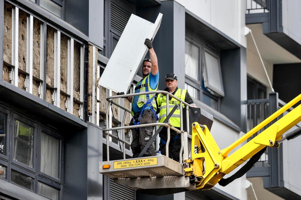  Workmen remove cladding from the exterior of Cannon Hussey Court in Salford, Manchester