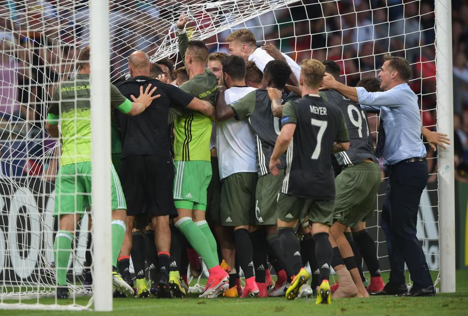  Germany players rush to mob goalkeeper Julian Pollersbeck after he saved two penalties in the shootout