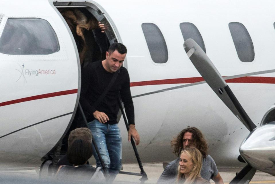  Xavi can been stepping off the plane while Carles Puyol is on runway