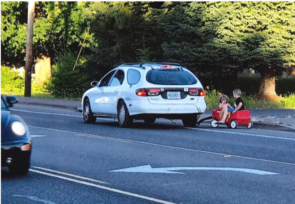  The two young kids pictured being towed by the car on a busy road in Oregon