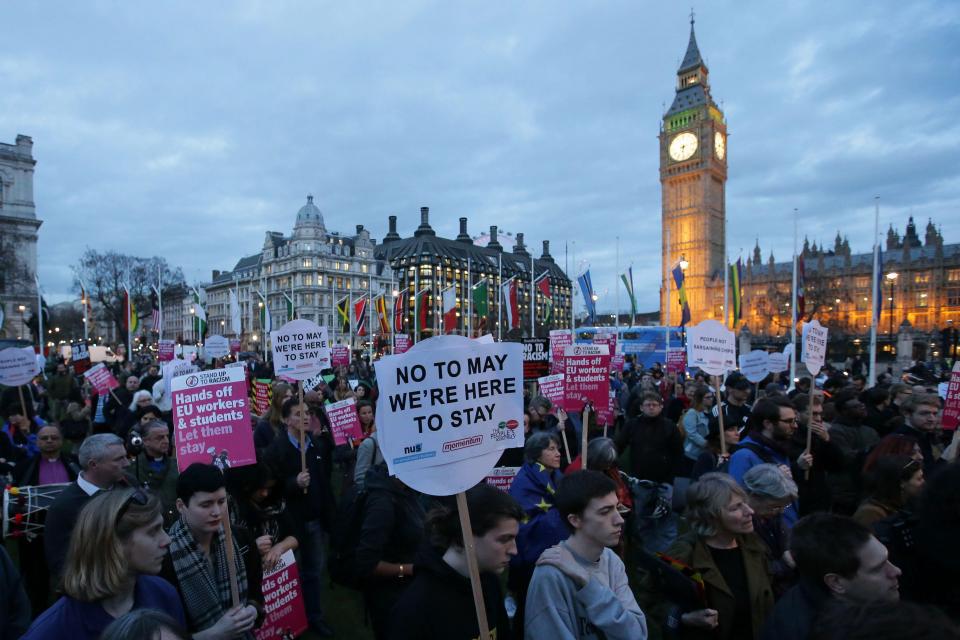 Protesters hold up placards as they take part in a protest in support of an amendment to guarantee legal status of EU citizens, outside the Houses of Parliament in London on March 2017