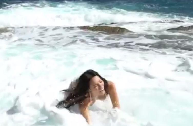  Her segment is cut short when a huge wave appears from no where and sweeps the model off her feet