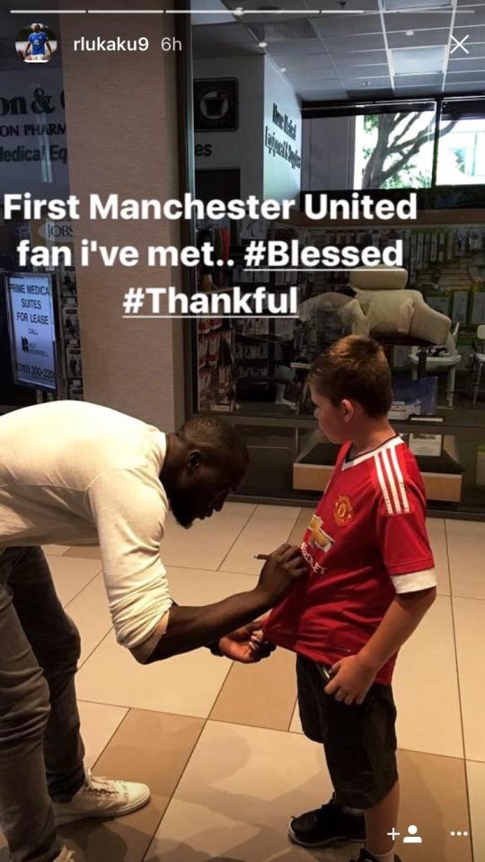 Romelu Lukaku signs a young Manchester United fan's shirt