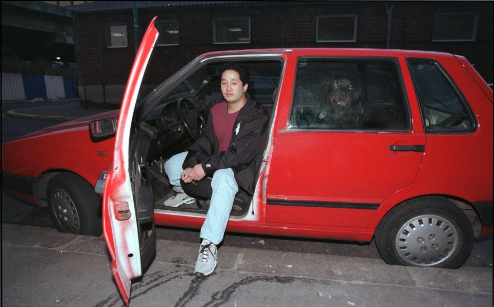 Van Thanh sits in his formerly white Fiat Uno after it was re-sprayed red 