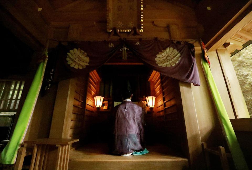  One of the priests holding a ritual ceremony at a shrine on the mysterious island