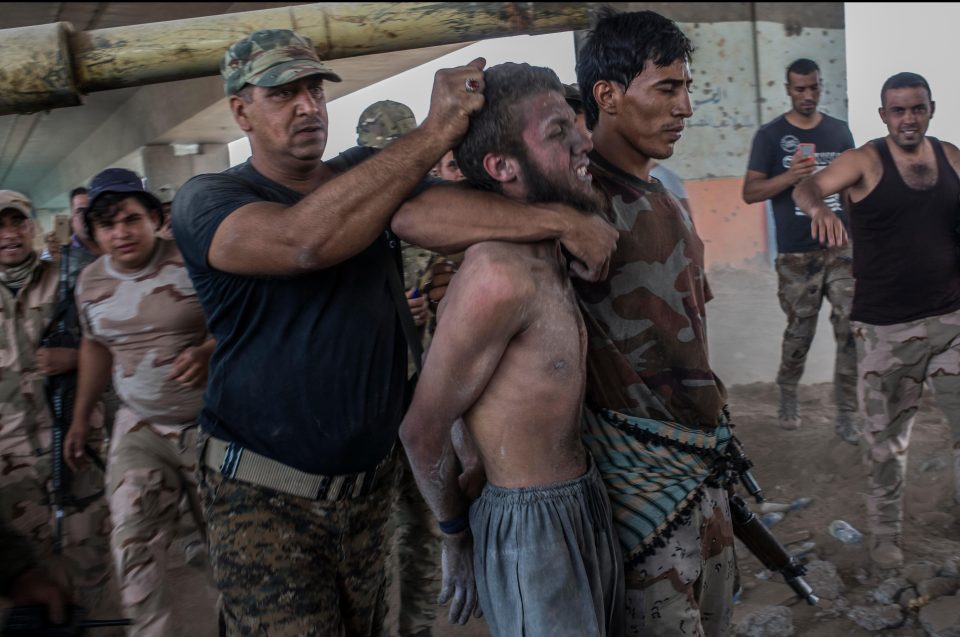  An ISIS fighter is pulled from the rubble of Mosul and arrested