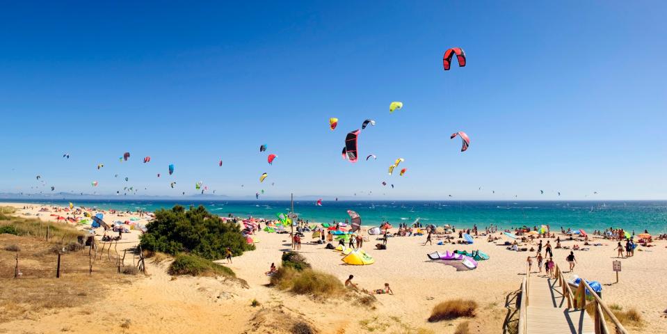  Holidaymakers kitesurf along the beach of Punta Paloma, Cadiz, Spain