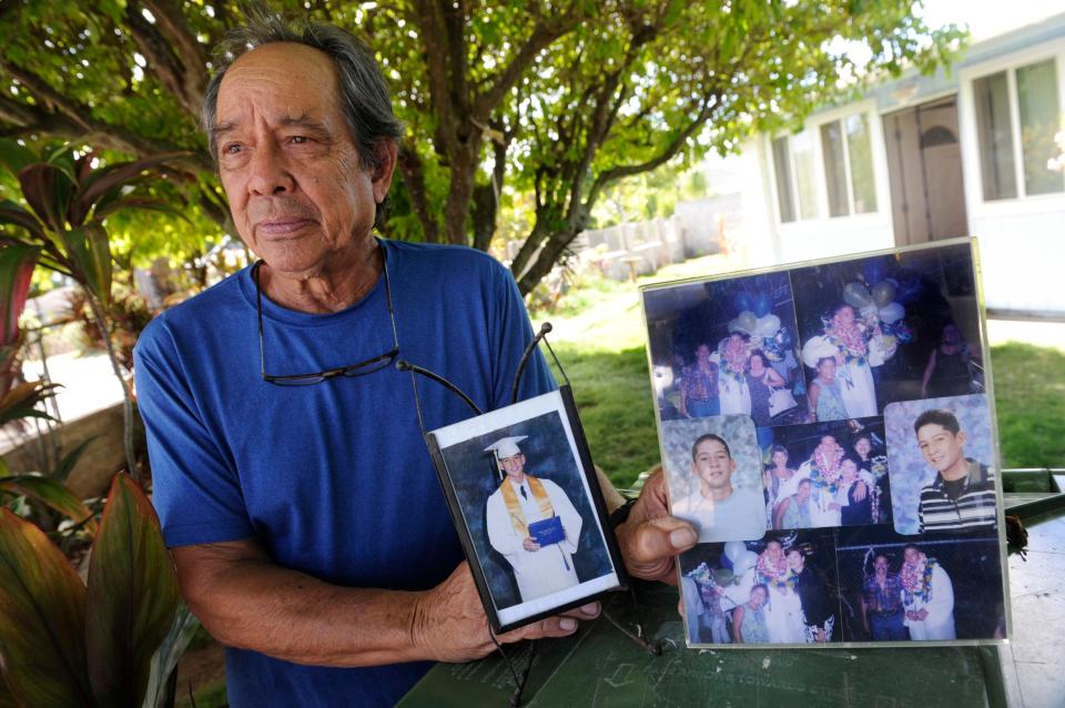  Clifford Kang, the father of soldier Ikaika Kang, poses with a photo of his son in Kailua, Hawaii