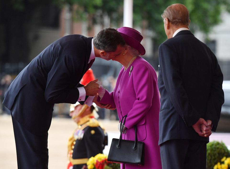  The Spanish King also gave the British Queen, who was dressed in a vibrant fuchsia coloured coat, a kiss on the cheek