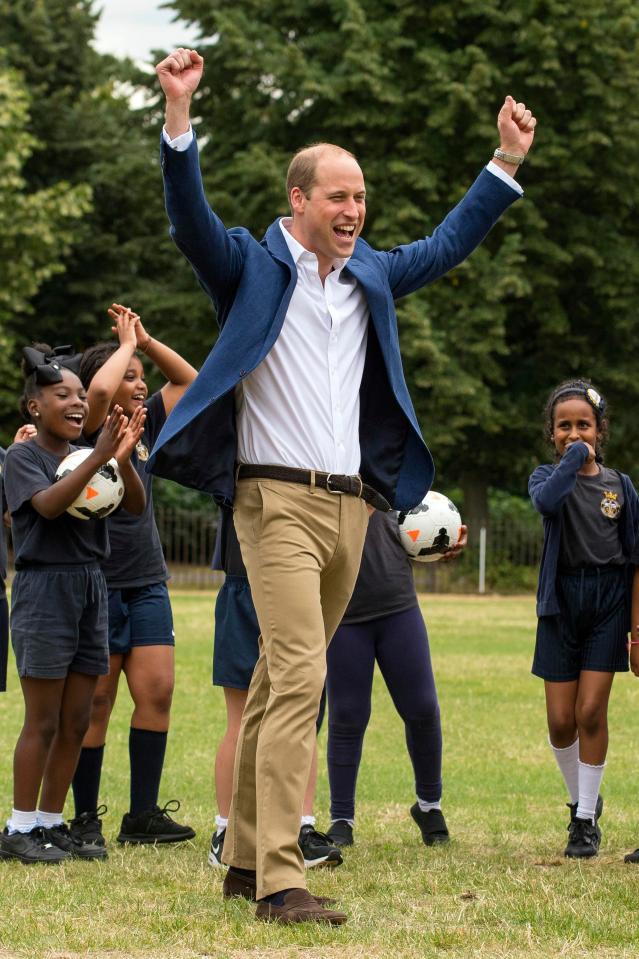  The royal raises his fists in delight as he shows off his own football skills