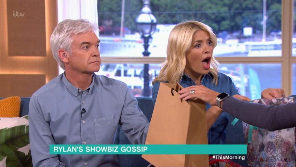  Rylan Clark-Neal handed them the official merchandise in paper bags