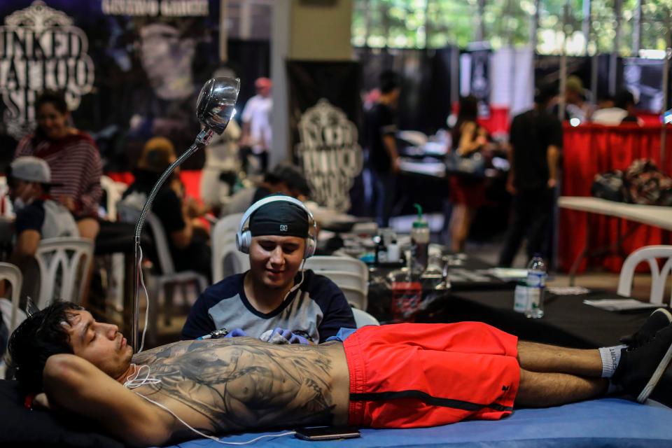  This man looks incredibly relaxed as he listens to music while being tattooed