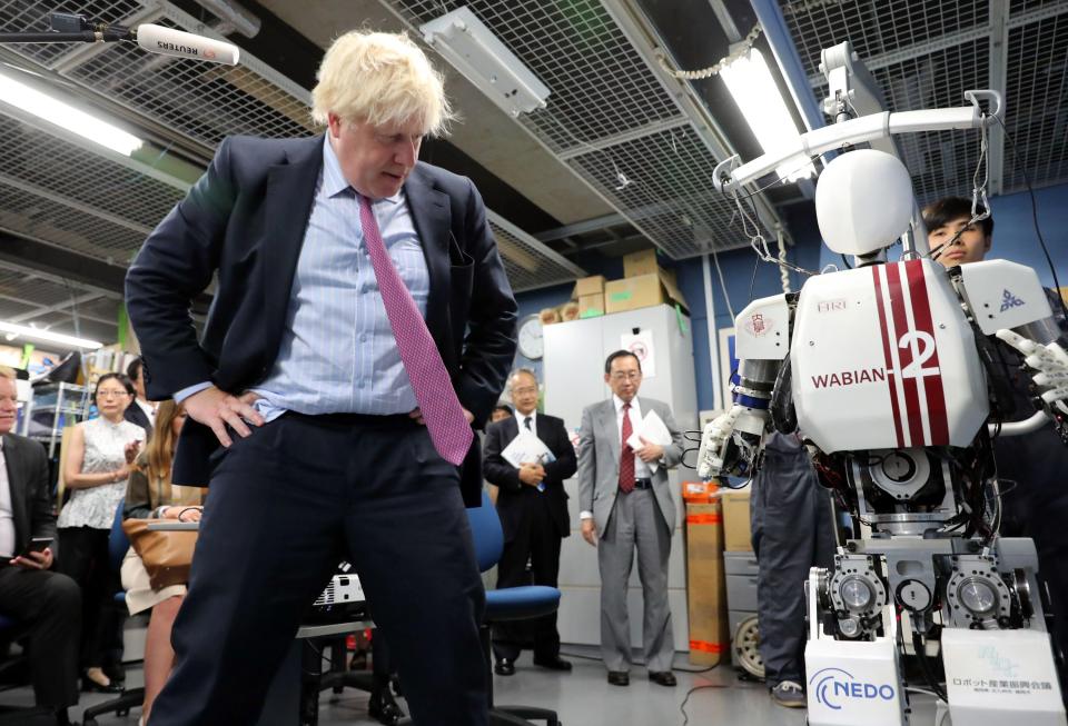  Mr Johnson struck a pose as he examined the hi-tech androids