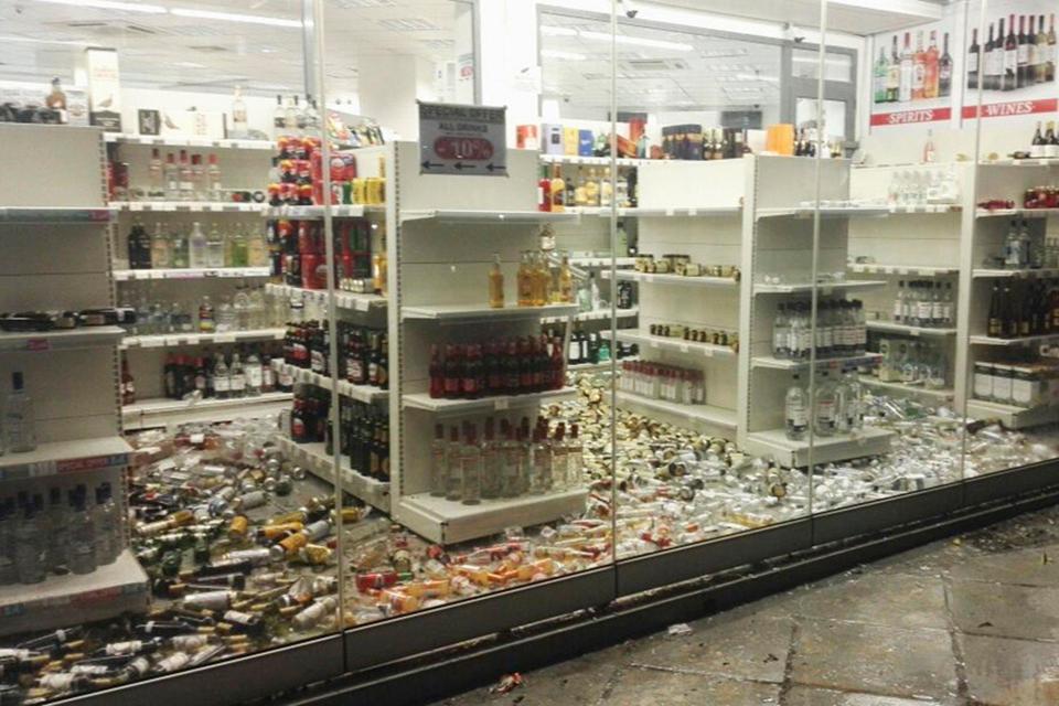  Smashed bottles cover the floor of an off licence on the island of Kos