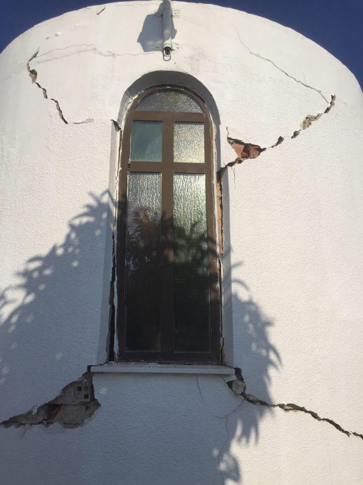  Huge cracks are seen around the window of a damaged church