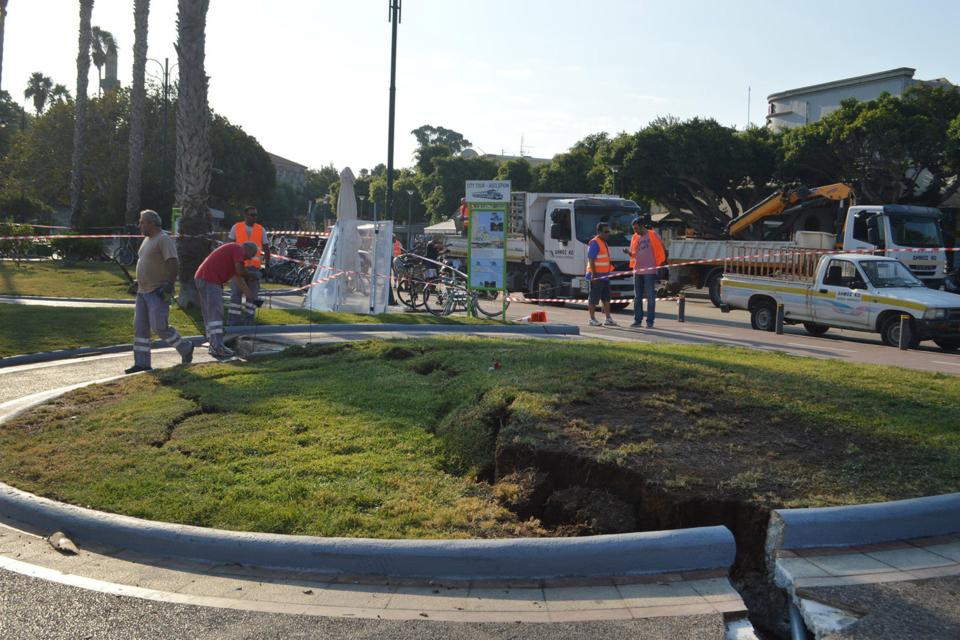  Workers are seen attending to damage at a square on Kos