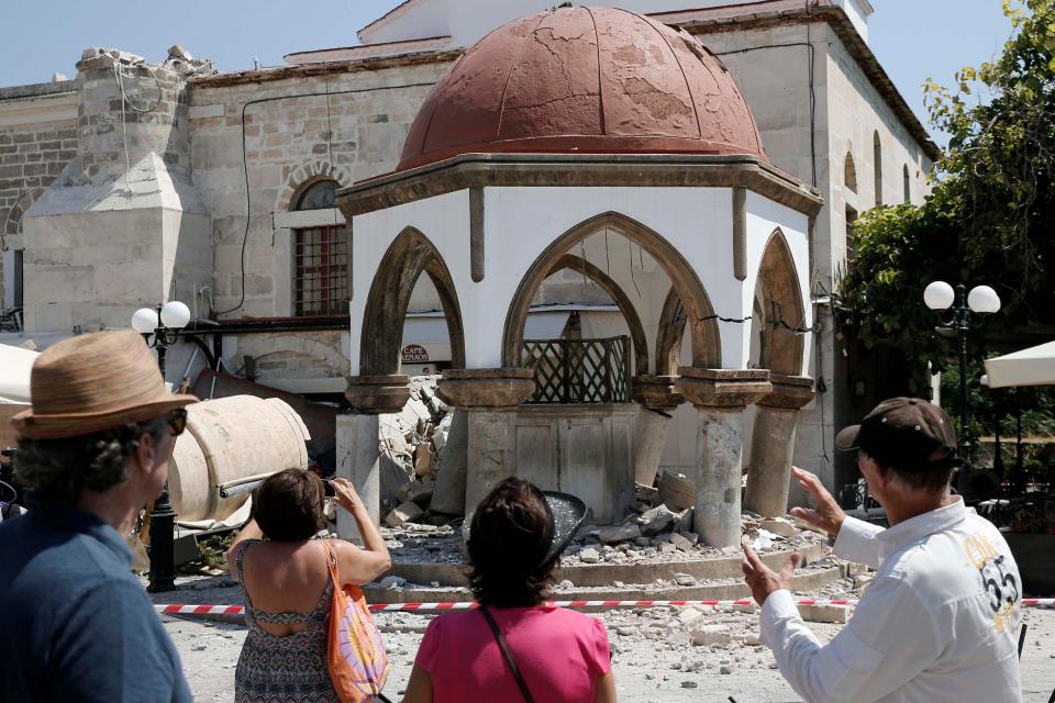  People look at the damaged Ottoman-era Defterdar mosque following the earthquake on the island of Kos