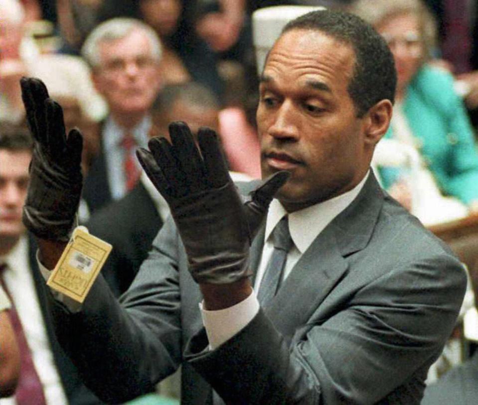  The former NFL star tries on the gloves during the trial which appear to be too small for his hands